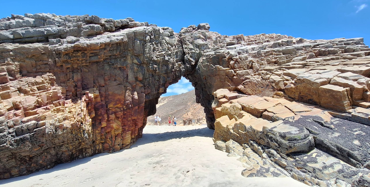Turistas ao fundo em visita a Pedra Furada