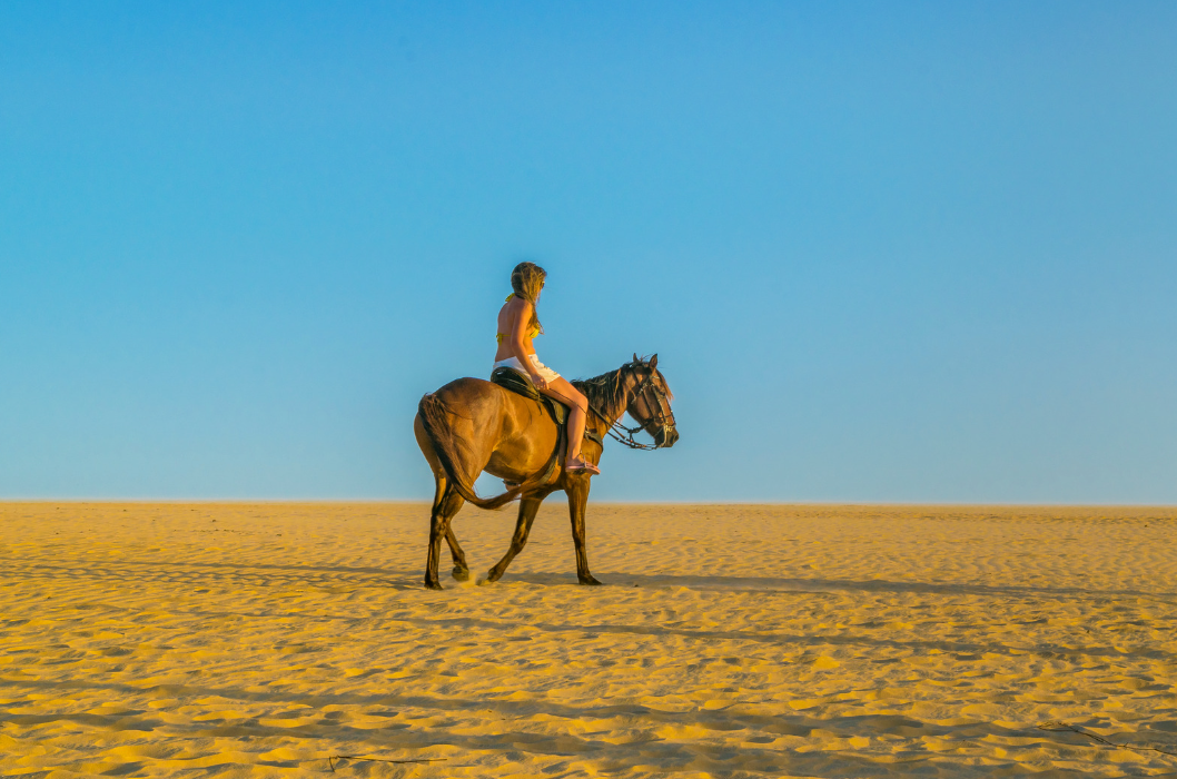 Turista passeando a cavalo pelas areias de Jericoacoara